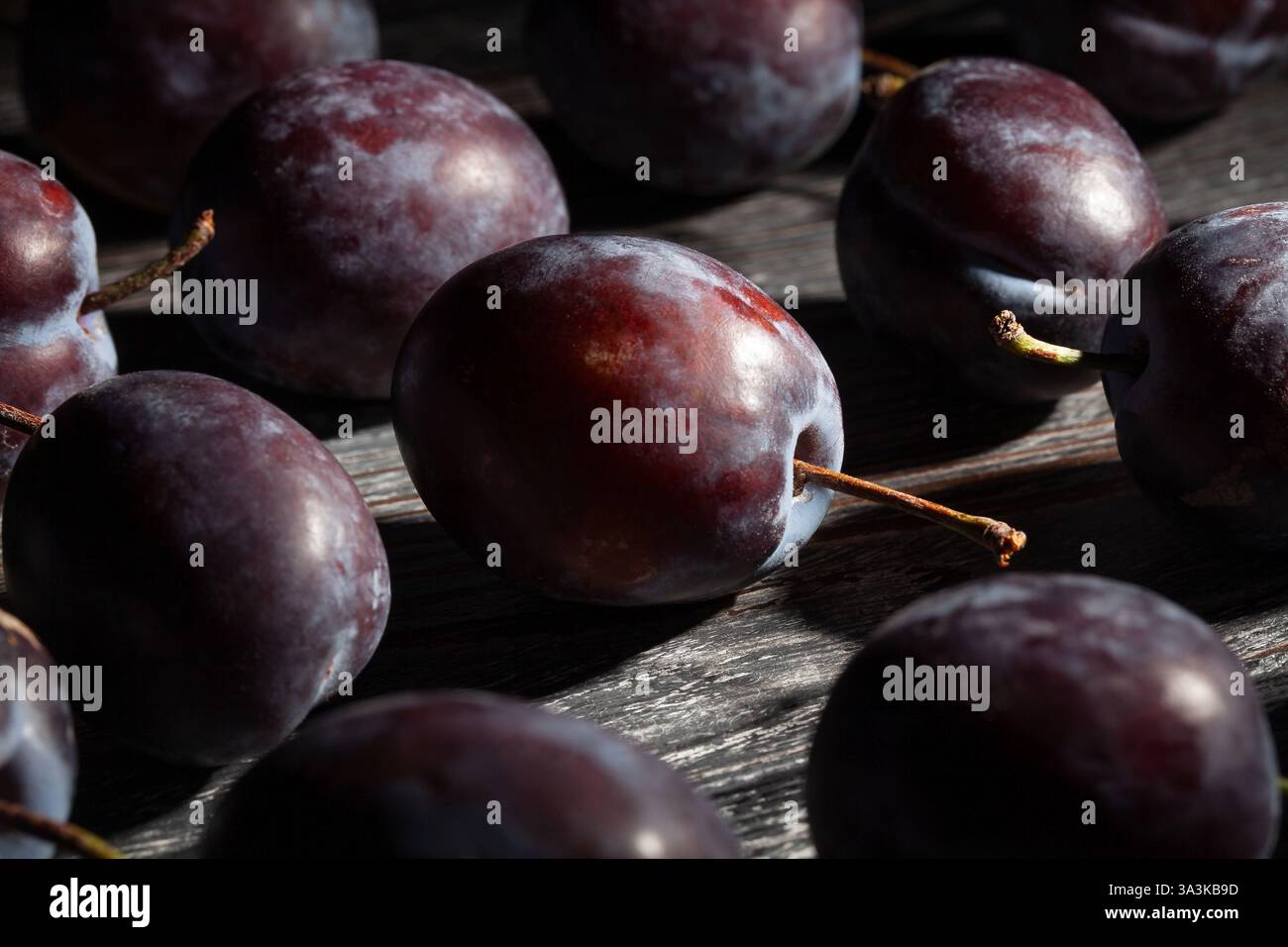 plums on black wood background Stock Photo