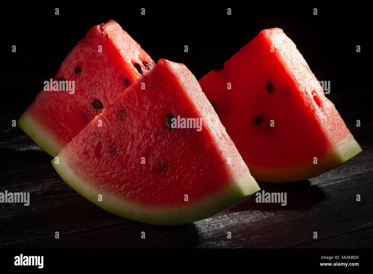sliced watermelon on black wood background Stock Photo