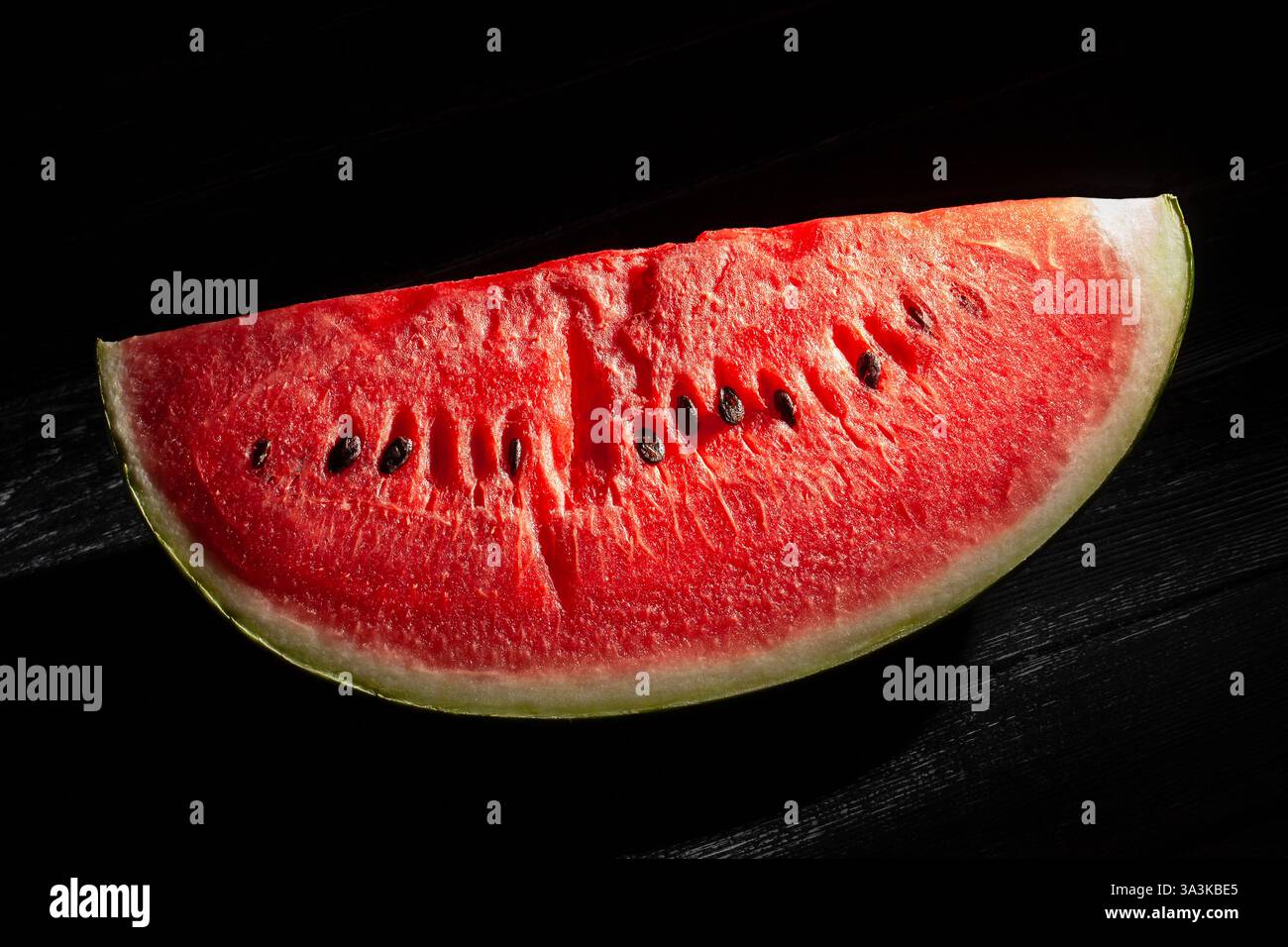 sliced watermelon on black wood background Stock Photo