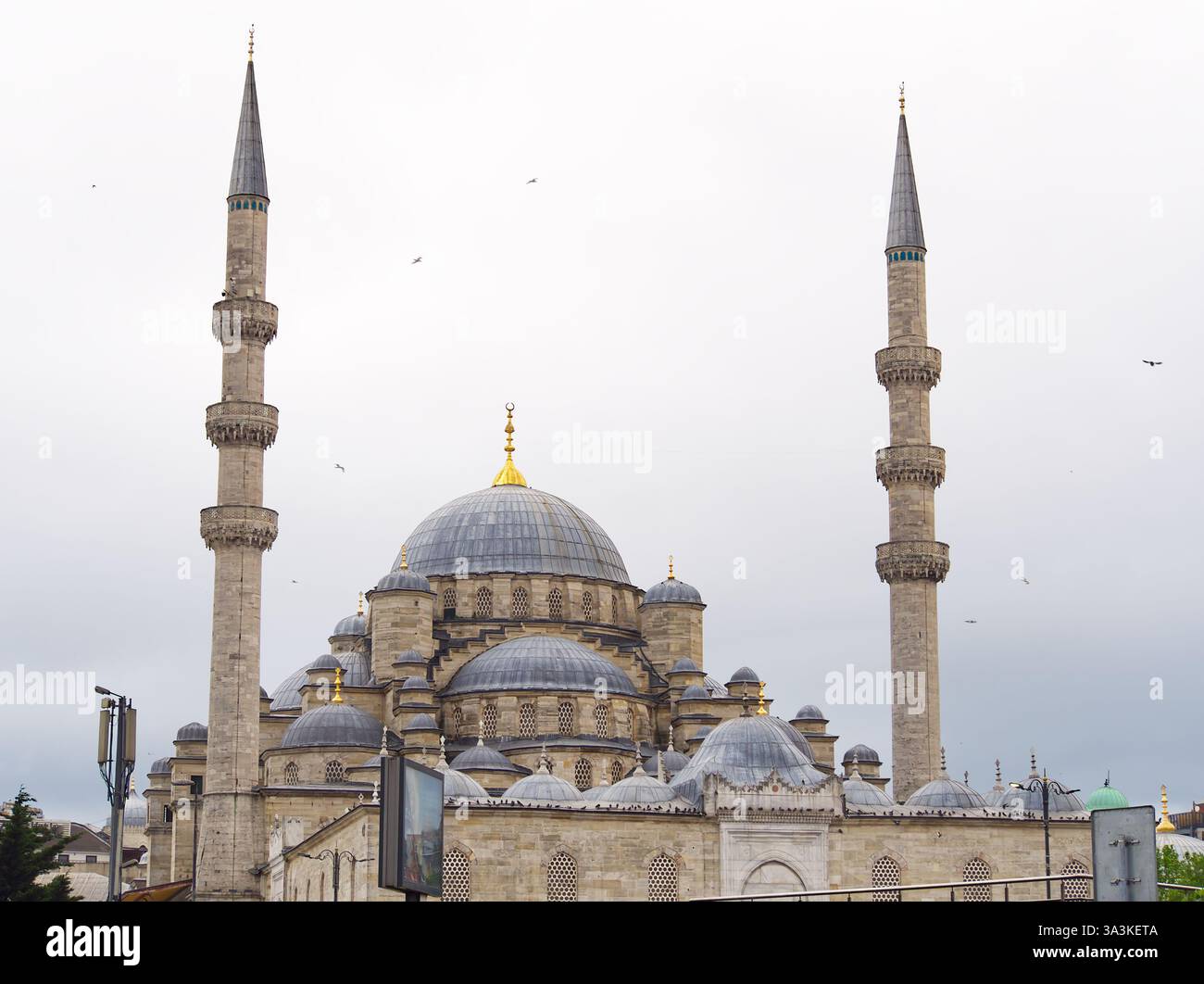 Majestic Ottoman-style mosque with a large central dome and two tall minarets against a cloudy sky Stock Photo