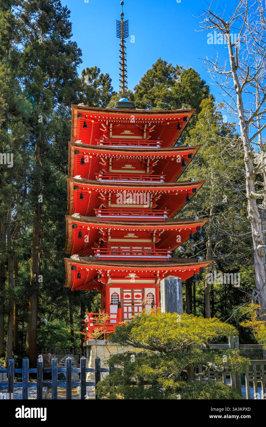 Vibrant red and white five tiered pagoda stands tall amidst lush green ...
