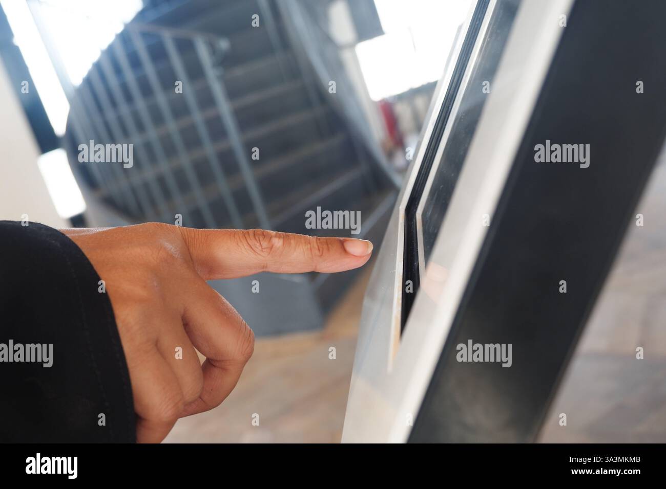 User interacting with digital touchscreen at a modern facility Stock Photo