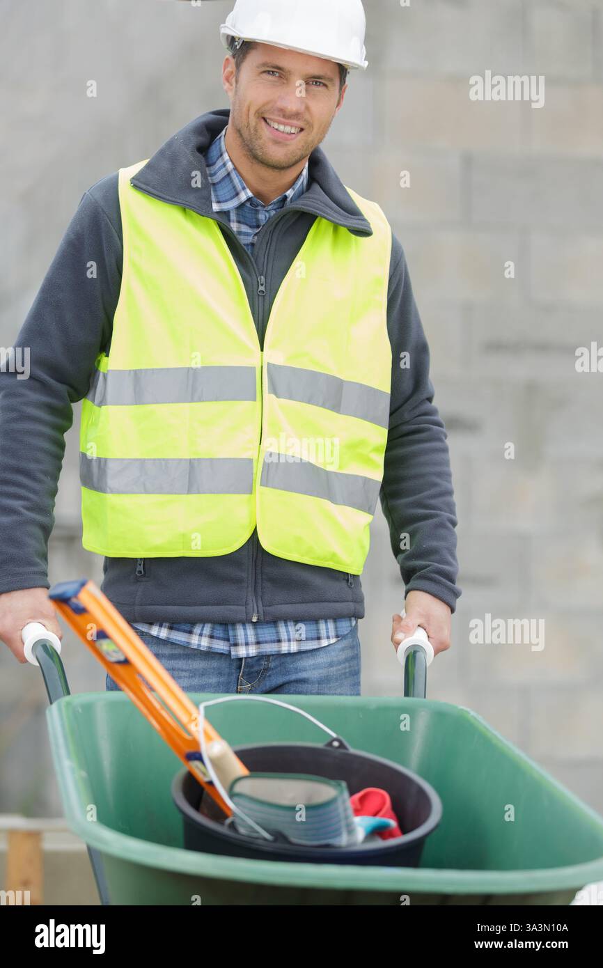 cheerful labourer pushing a clean wheelbarrow Stock Photo