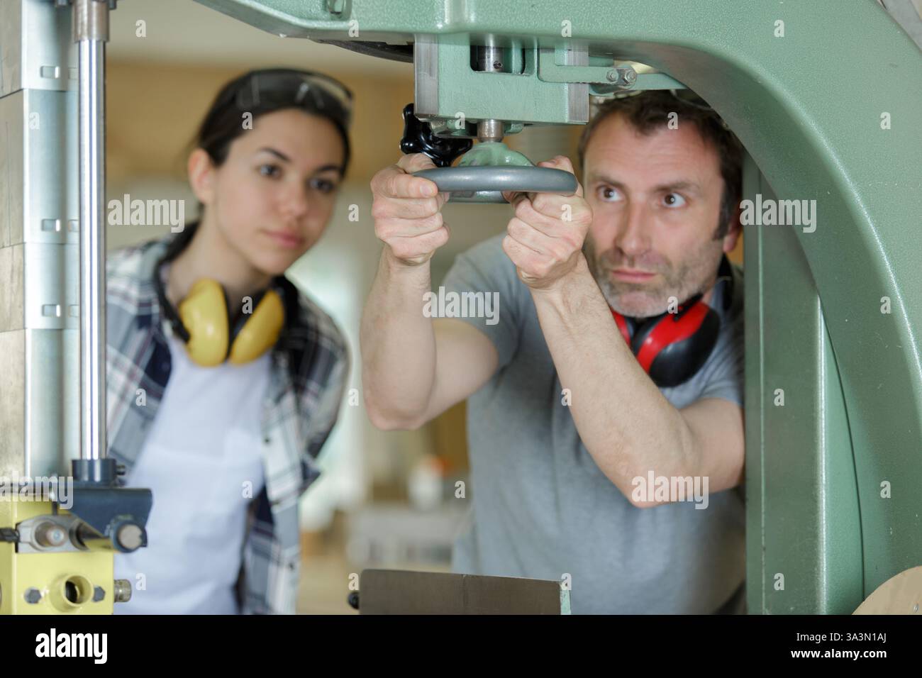 man working with female apprentice in factory Stock Photo