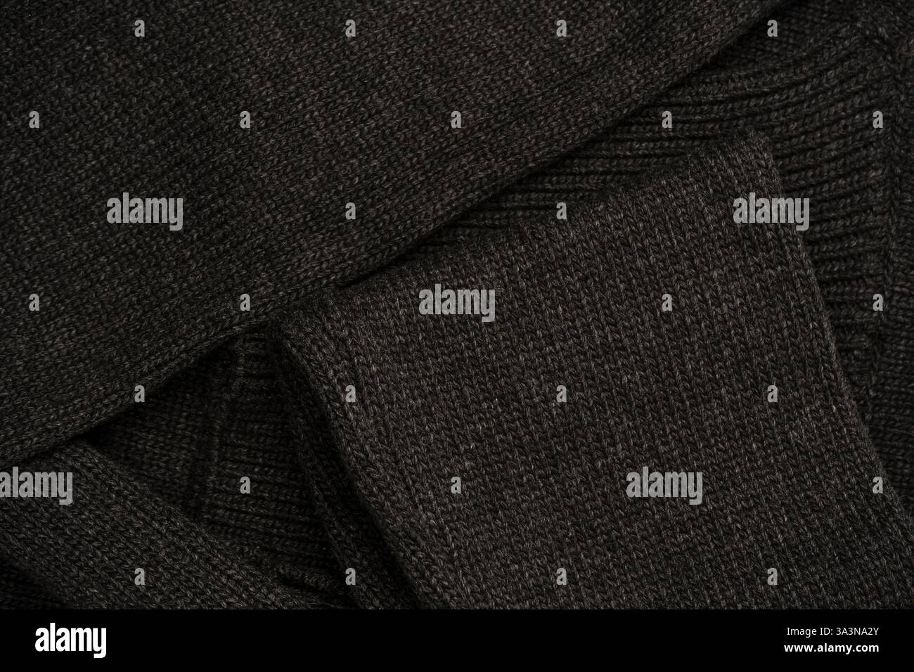 Dark grey sweater texture as a background. Knitted pattern. Top view. Stock Photo