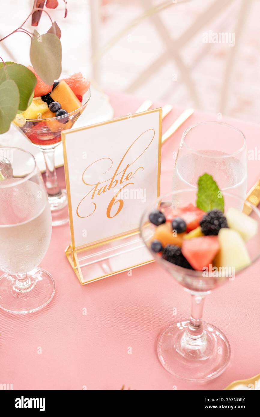 Elegant table setting with fruit cups and table number signage. Stock Photo