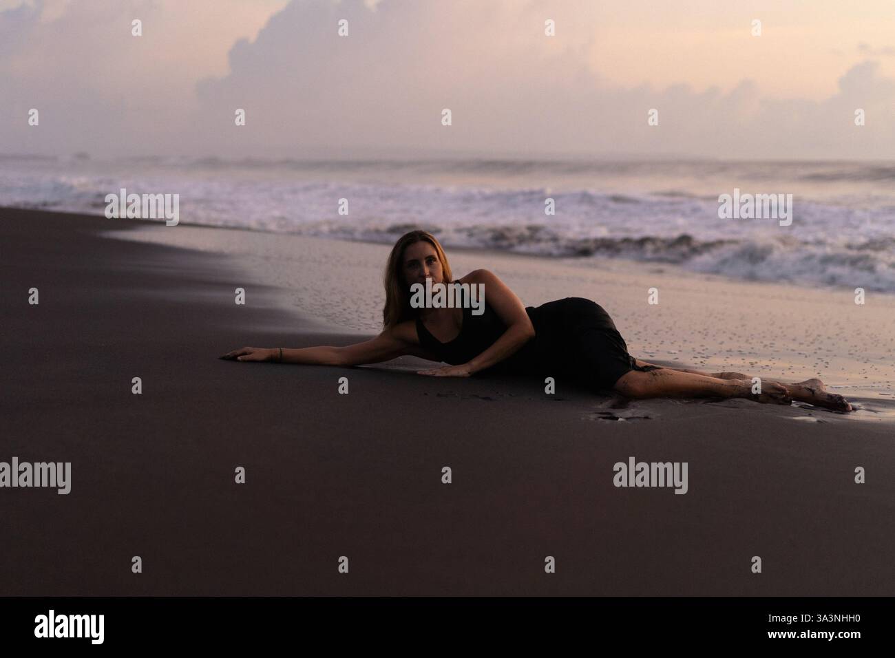 Beautiful woman lying on the sand on the beach at sunset. Bali Stock ...