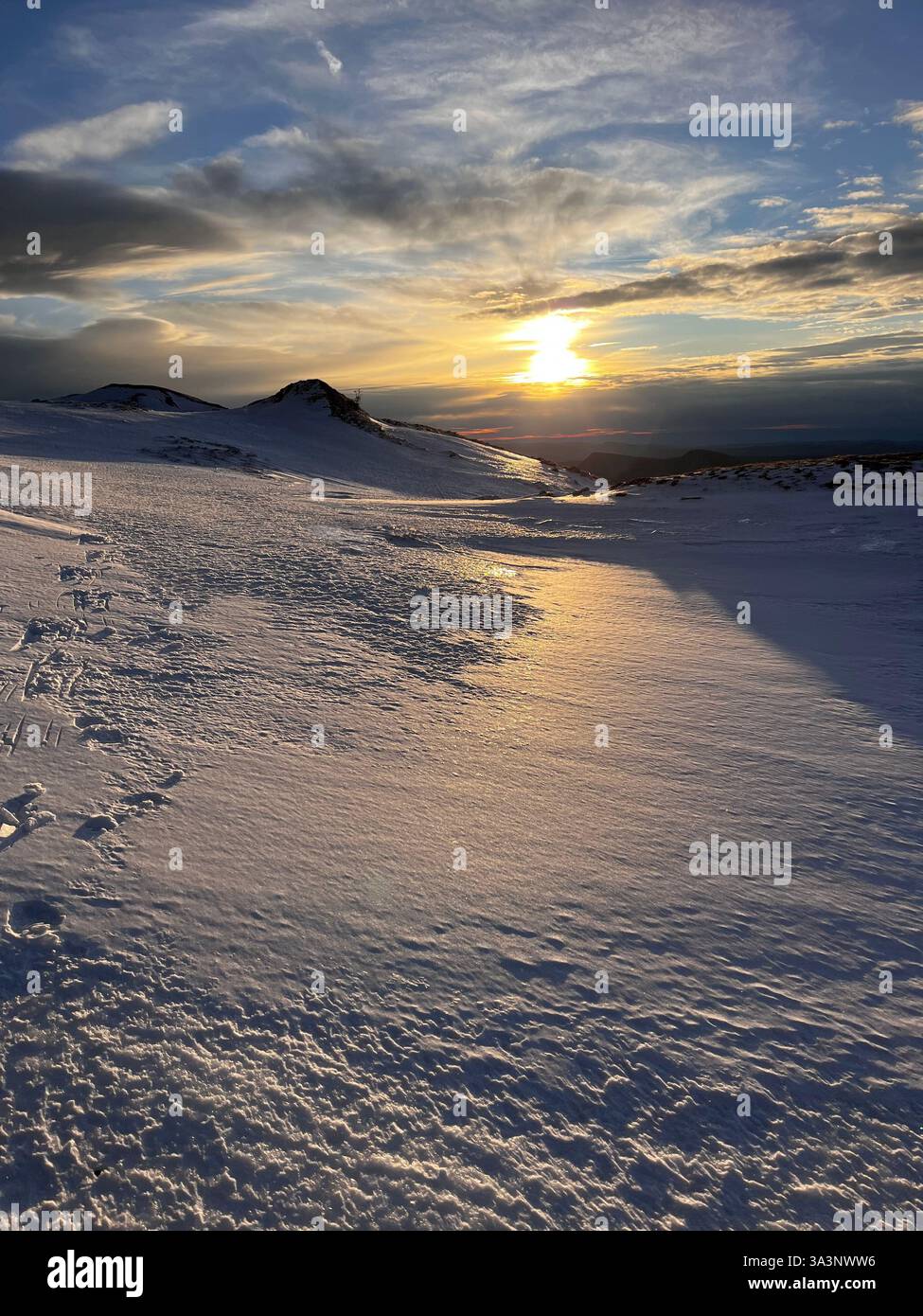 The frozen mountains of the French Jura at sunset, marked by snowshoe tracks. - Smartphone Captured Stock Image