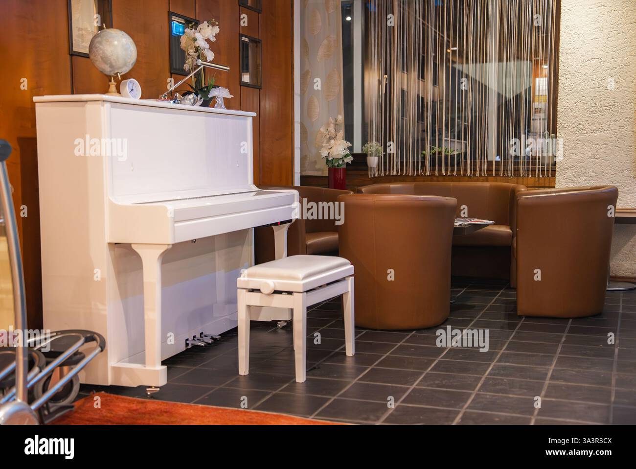 cozy-interior-with-white-piano-and-leather-seating-area-stock-photo-alamy