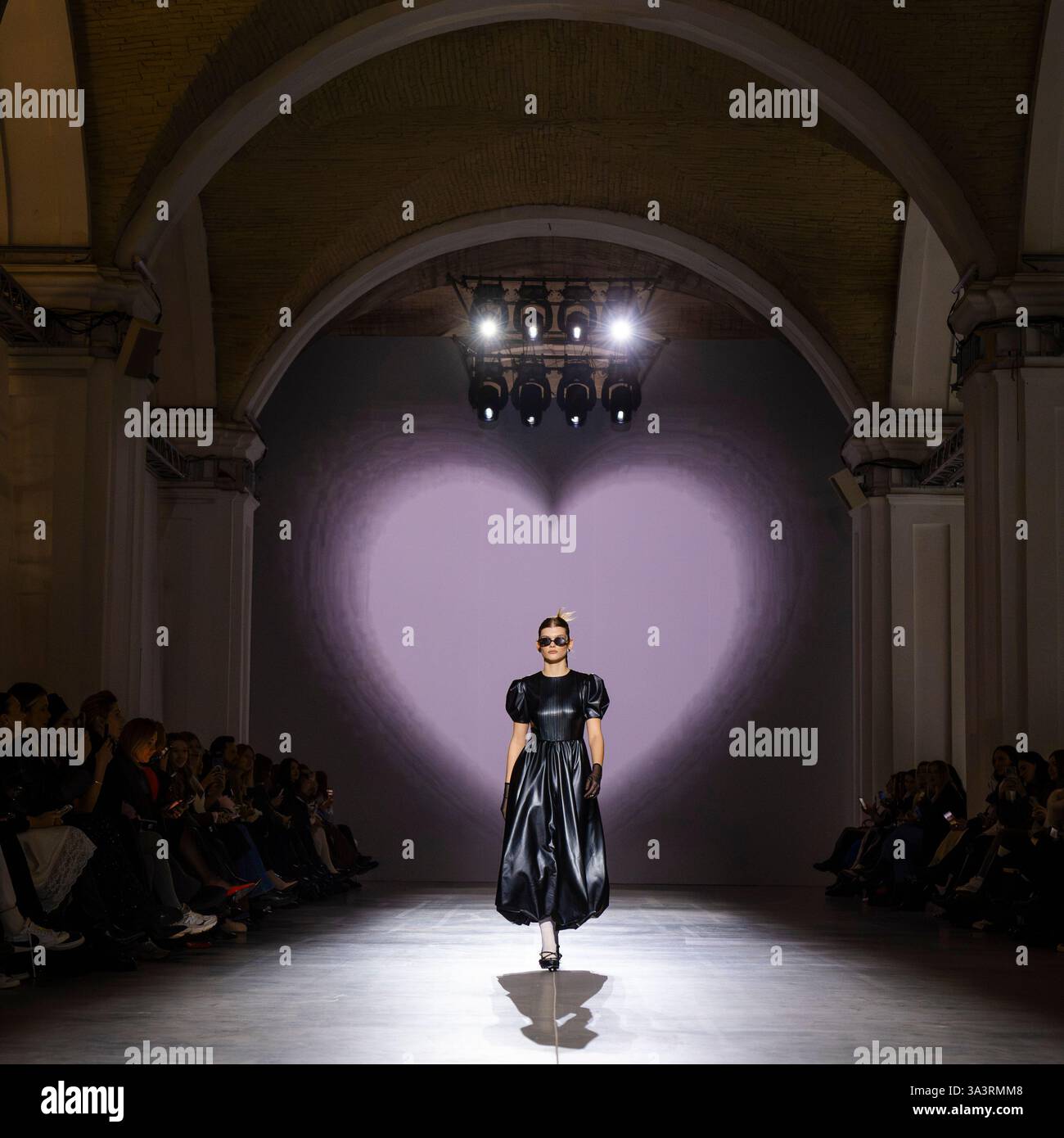 Kyiv, Ukraine - 14th February, 2025. A model showcases a stunning black ensemble with a puff-sleeved silhouette, reflecting modern elegance amid a hea Stock Photo