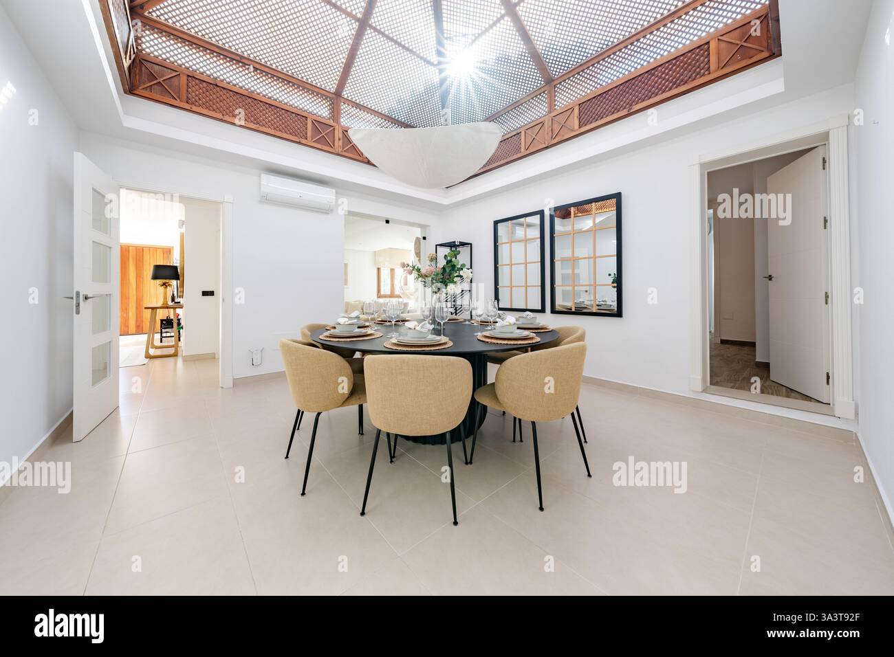 a luxury dining room with round table and skylight in mediterranean ...