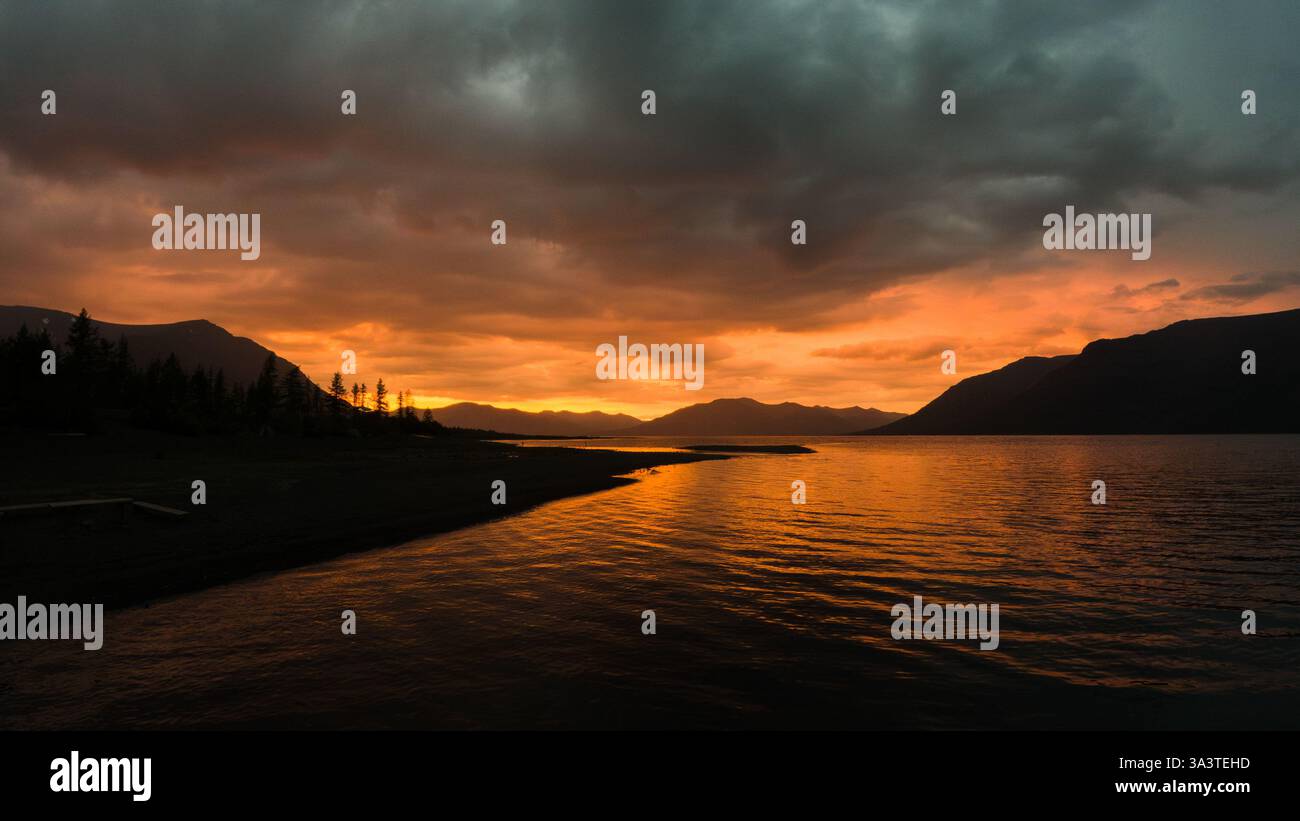 Fiery Sunset Over Mountain Lake Stock Photo