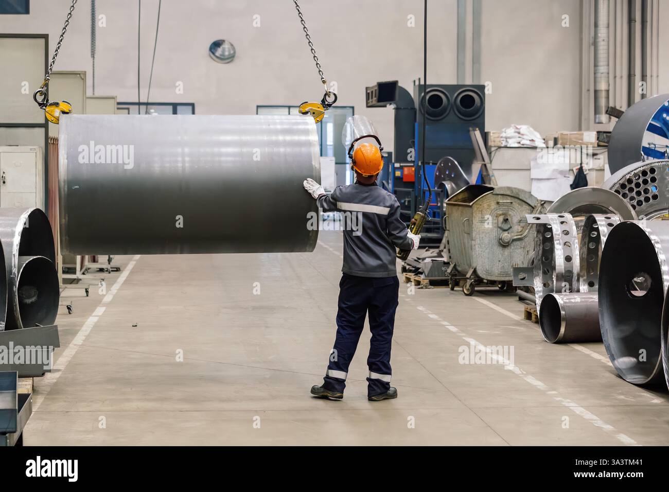 Pipe on overhead crane. Worker with remote control. Stock Photo