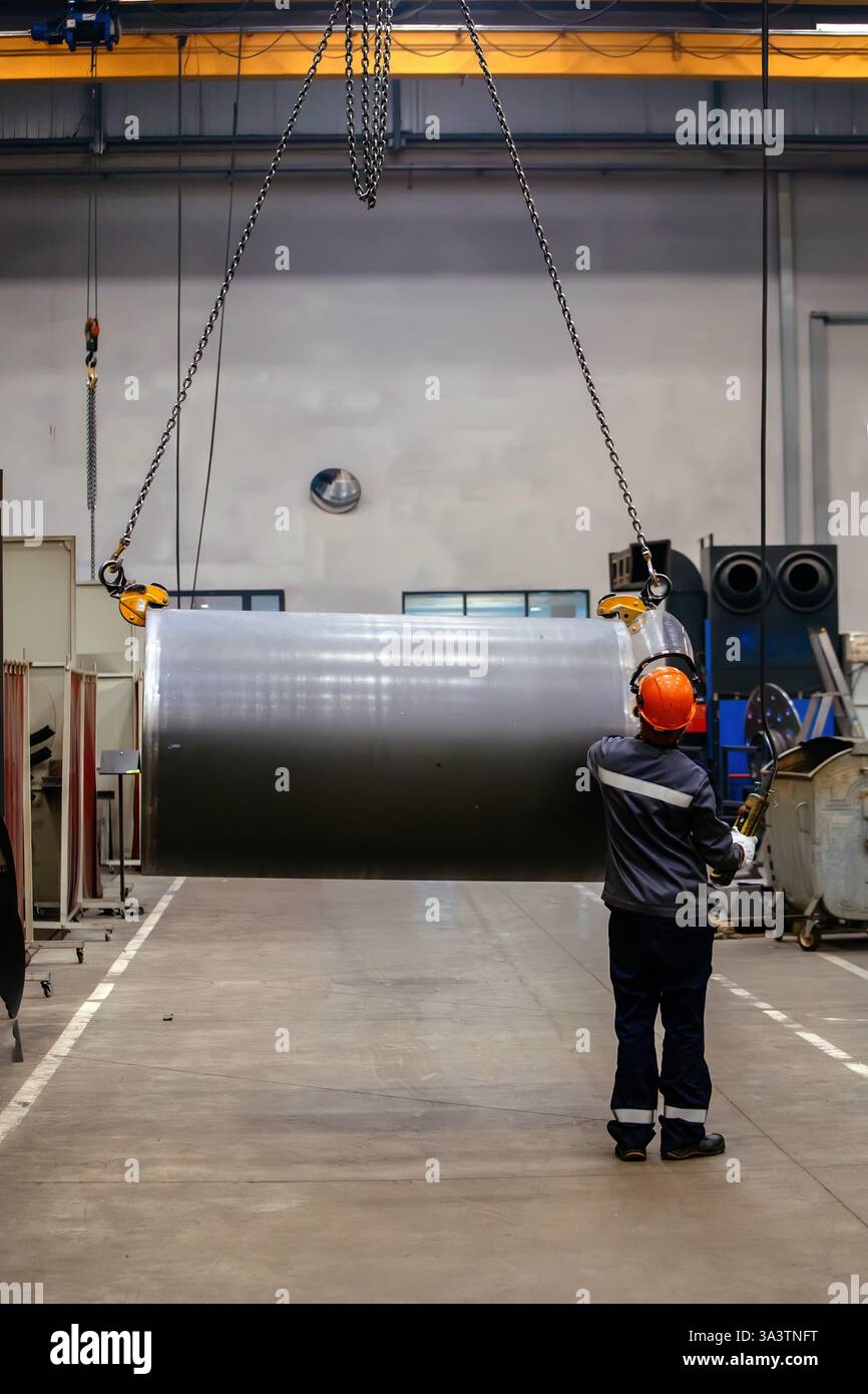 Pipe on overhead crane. Worker with remote control. Stock Photo