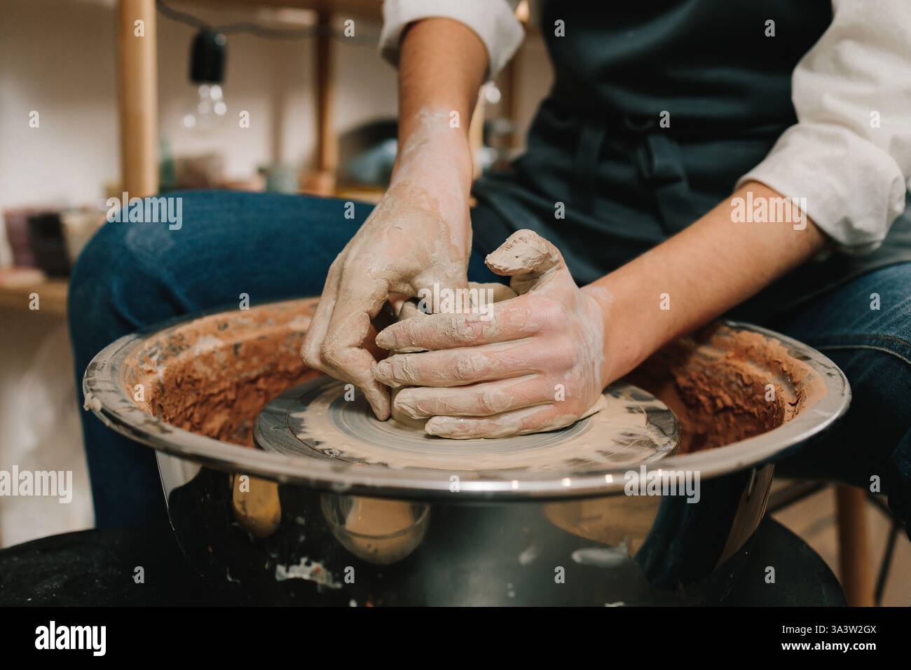 Artisan molds a piece of wet clay on the pottery wheel. Process of ...
