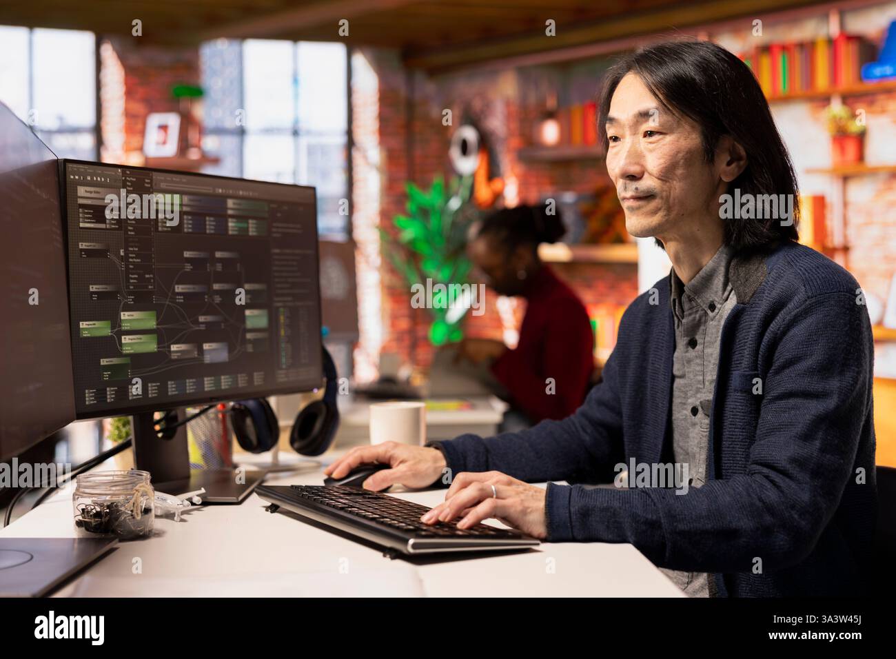 Senior technician coding advanced AI algorithm in startup office, refining machine learning models to enhance automation. Asian CTO manager using coding platform in Silicon Valley workplace Stock Photo