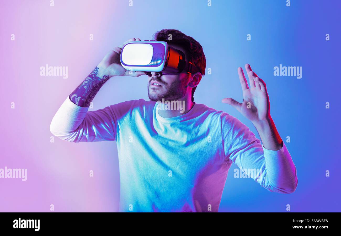 Young man explores VR with an immersive headset in a vibrant setting ...