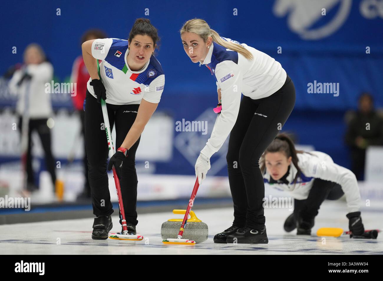 Italy's skip Stefania Constantini, right, looks at the stone as Italy's ...