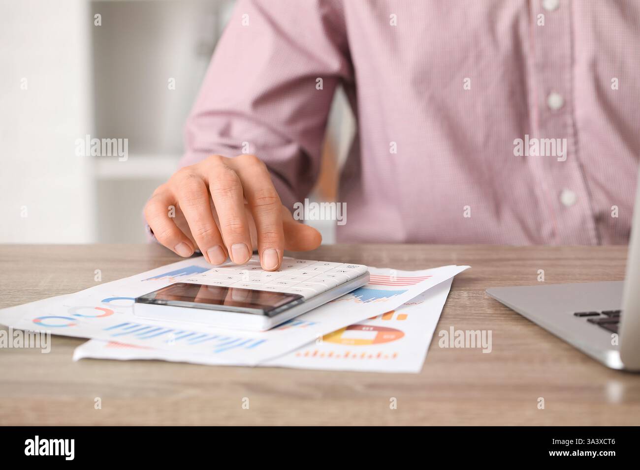 Office worker using calculator at table. Closeup Stock Photo