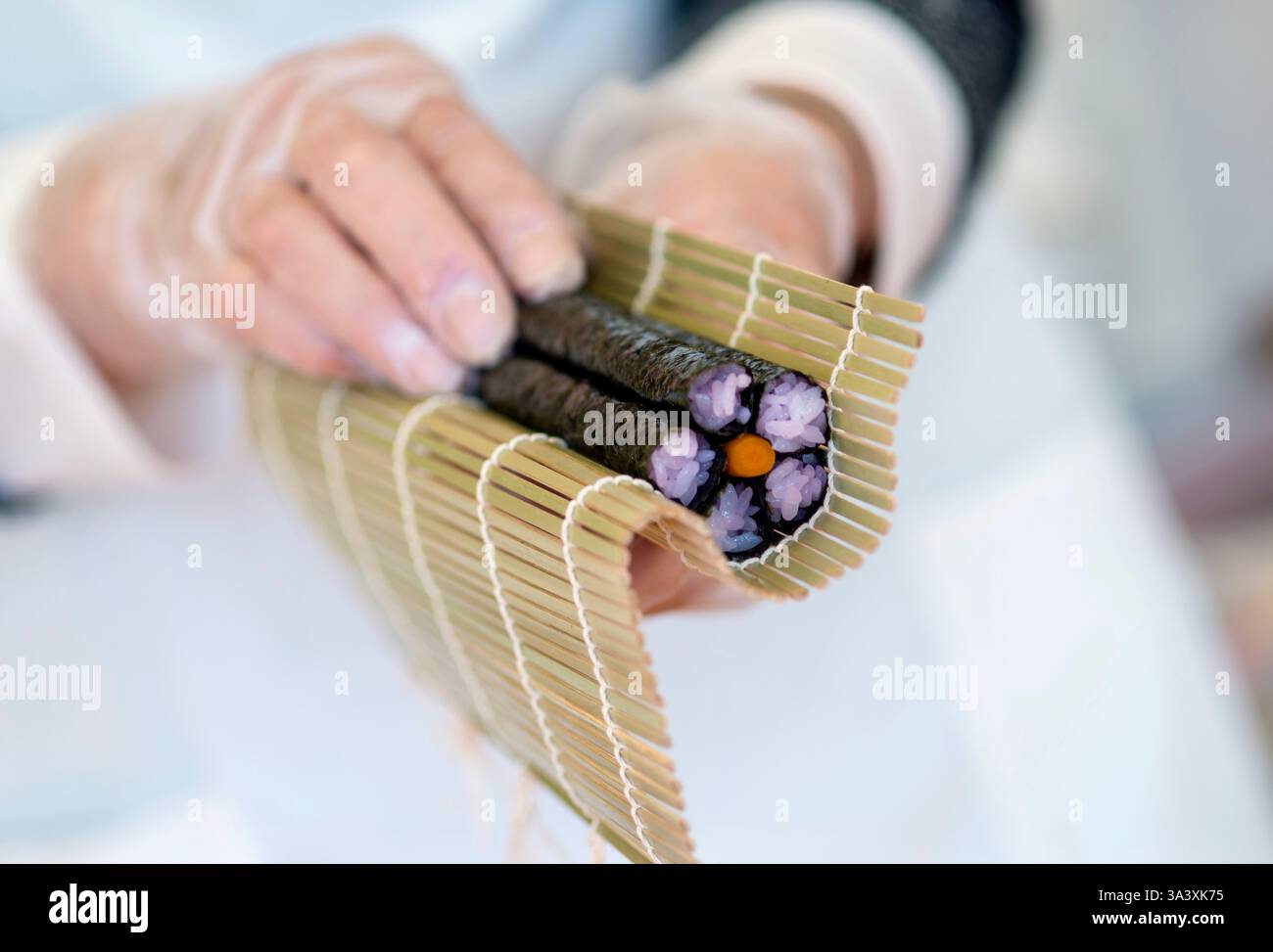 Yoshiko Minegishi creates a flower design in a futomaki matsuri sushi (thick festive rolls) at Hanamiyui, a cooking school in Kamogawa,  Chiba Prefect Stock Photo