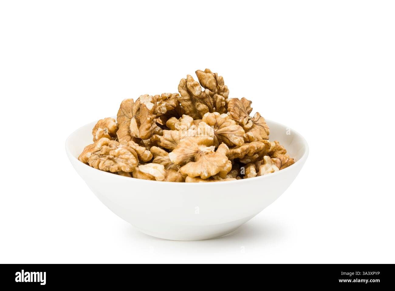 Shelled walnuts into bowl on white background. Stock Photo