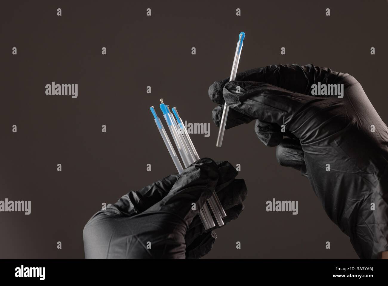 concept dry needling method. Close-up of black-gloved hands holding sterile acupuncture needles in protective tubes, symbolizing alternative medicine, Stock Photo