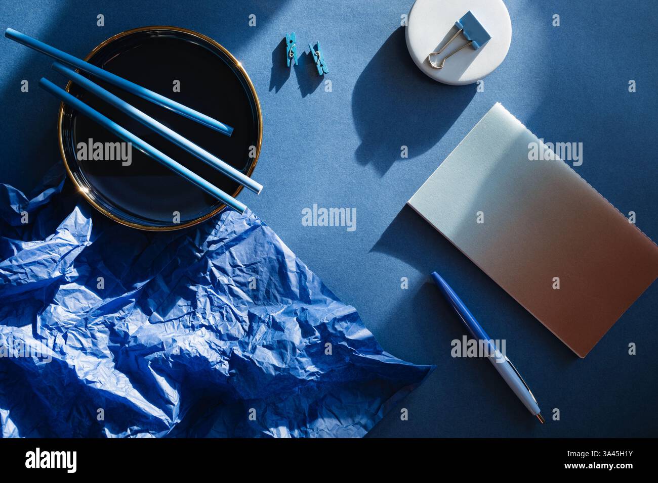 Overhead view of assorted stationery on a blue background Stock Photo