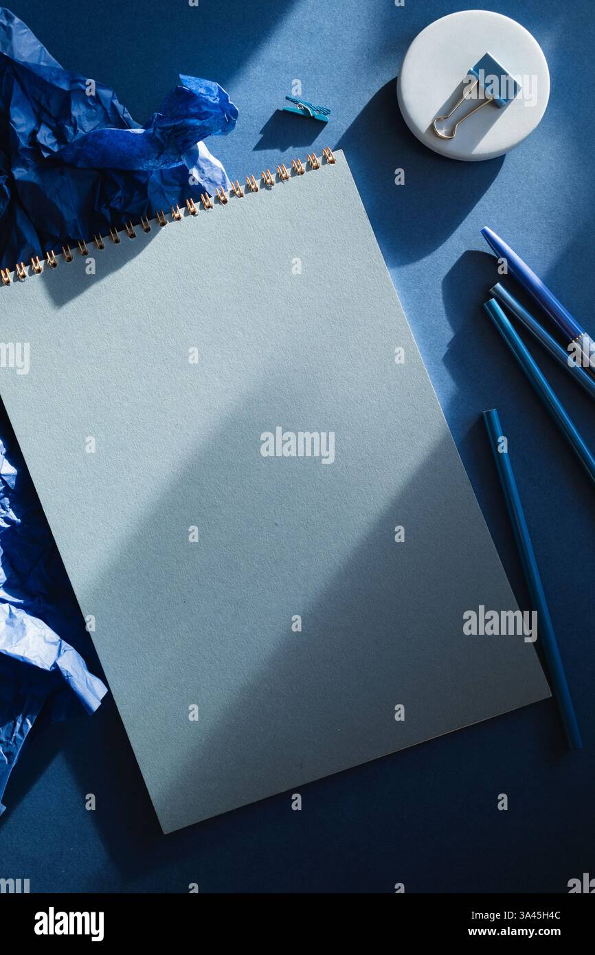 Office desk with stationery on blue background in contrast light Stock Photo