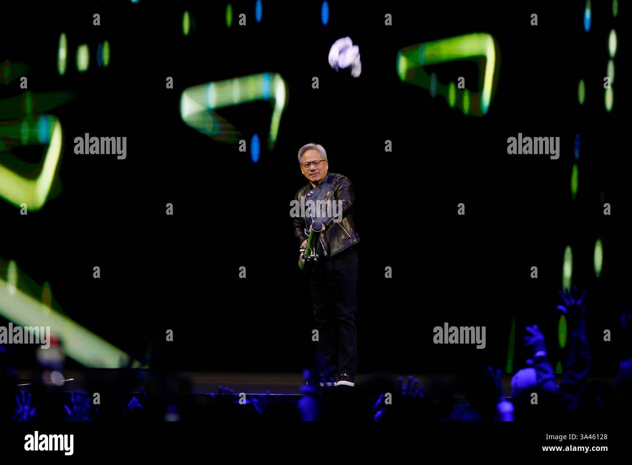 Nvidia CEO Jensen Huang gives away swag to attendees on stage during ...