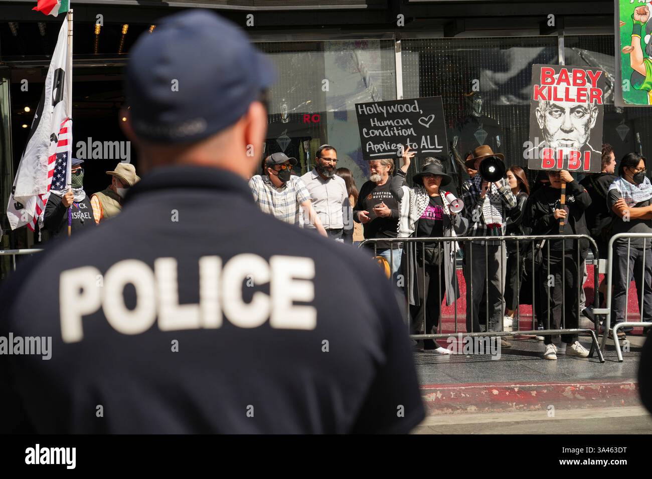 EDS NOTE: OBSCENITY - Police stand watch as people hold signs ...