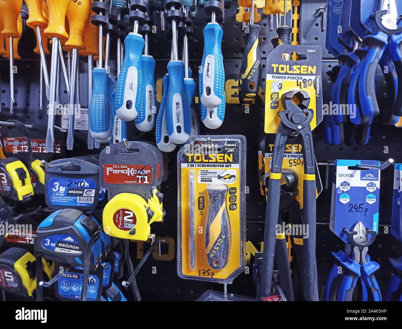 Assorted hand tools displayed on wall in hardware store. Stock Photo