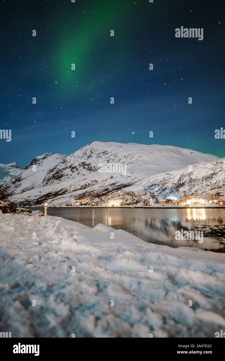 Aurora borealis over snowy mountains by fjord in the arctic, Ersfjord ...