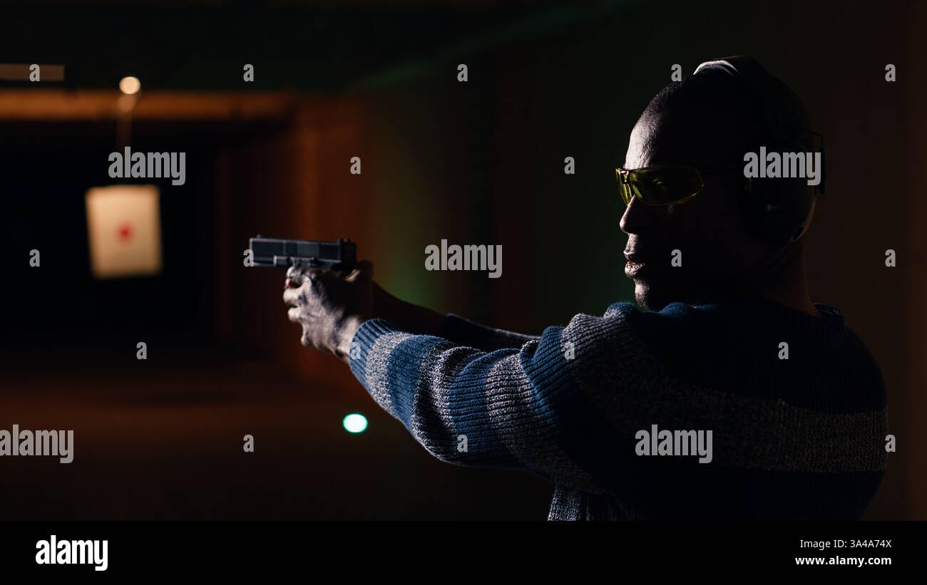 Portrait of happy shooting range customer reloading pistol, shooting ...