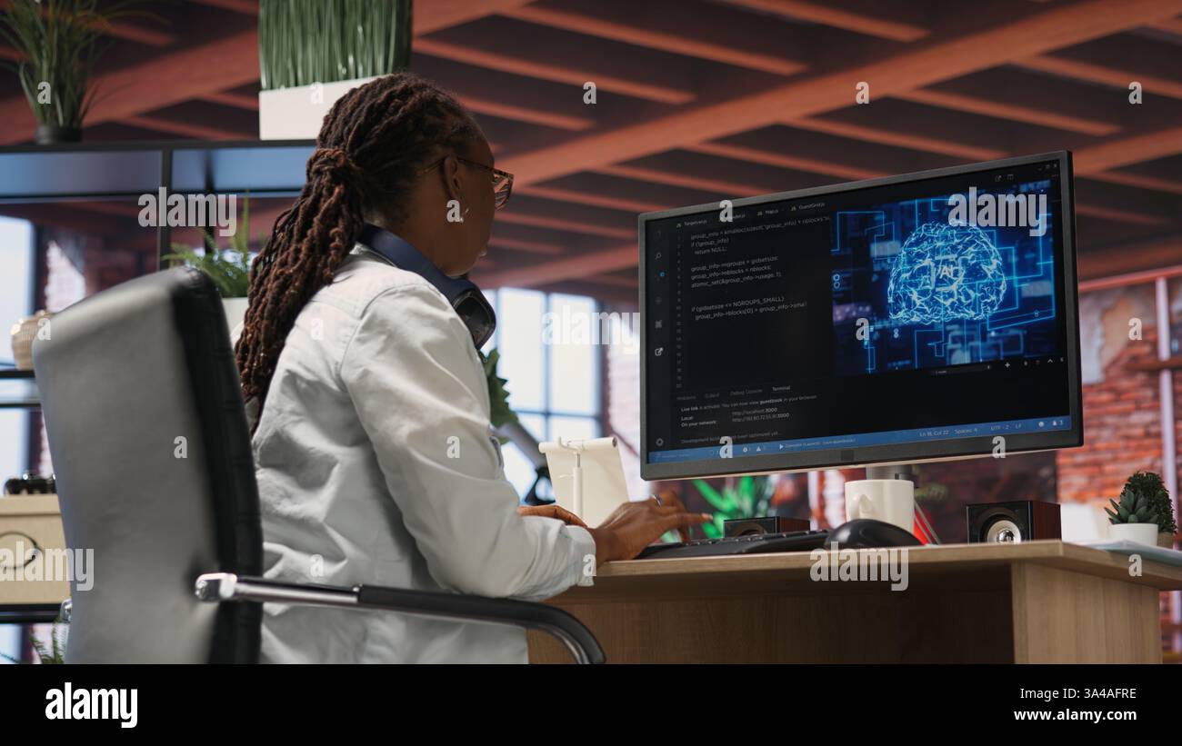 Teleworking programmer using computer for artificial intelligence computing through self learning algorithms. Remote worker working with AI deep neural networks on desktop PC, camera B Stock Photo