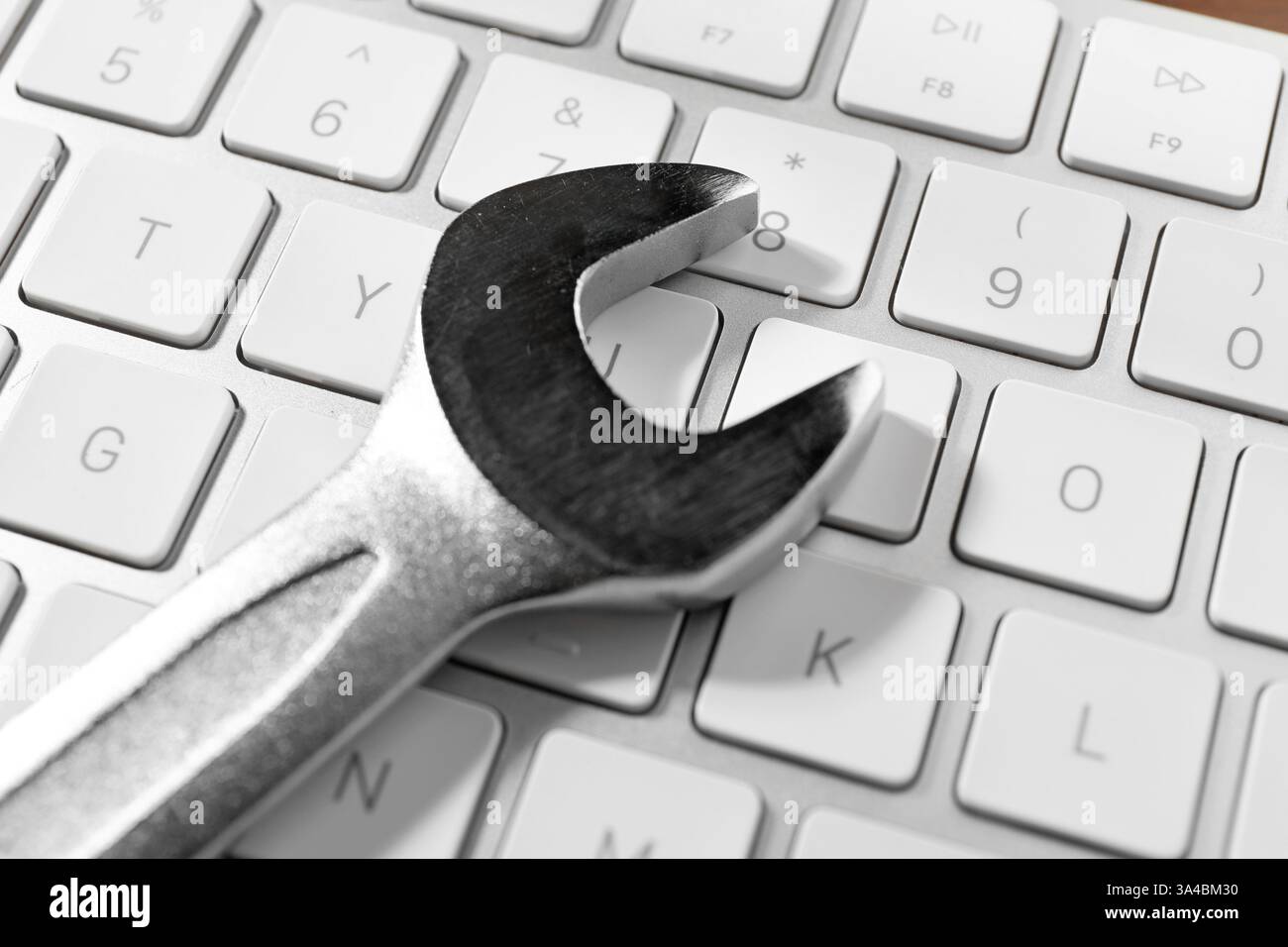 Technical support concept. Wrench on keyboard, closeup Stock Photo