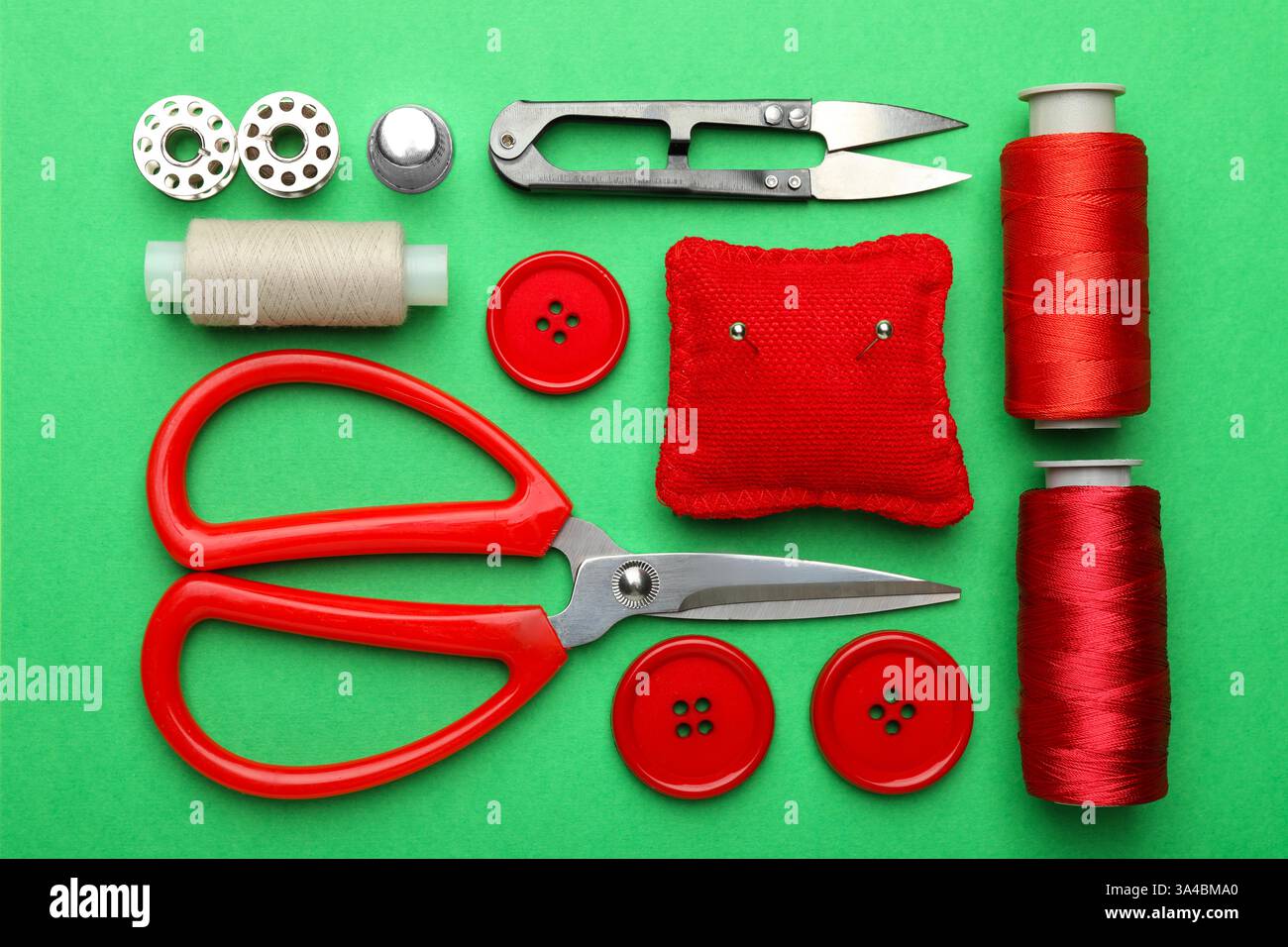 Different sewing supplies on green background, flat lay Stock Photo