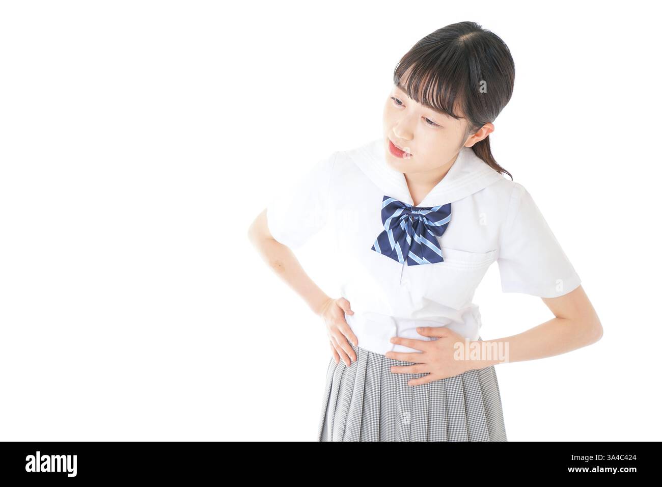Schoolgirl in school uniform suffering from menstrual cramps Stock