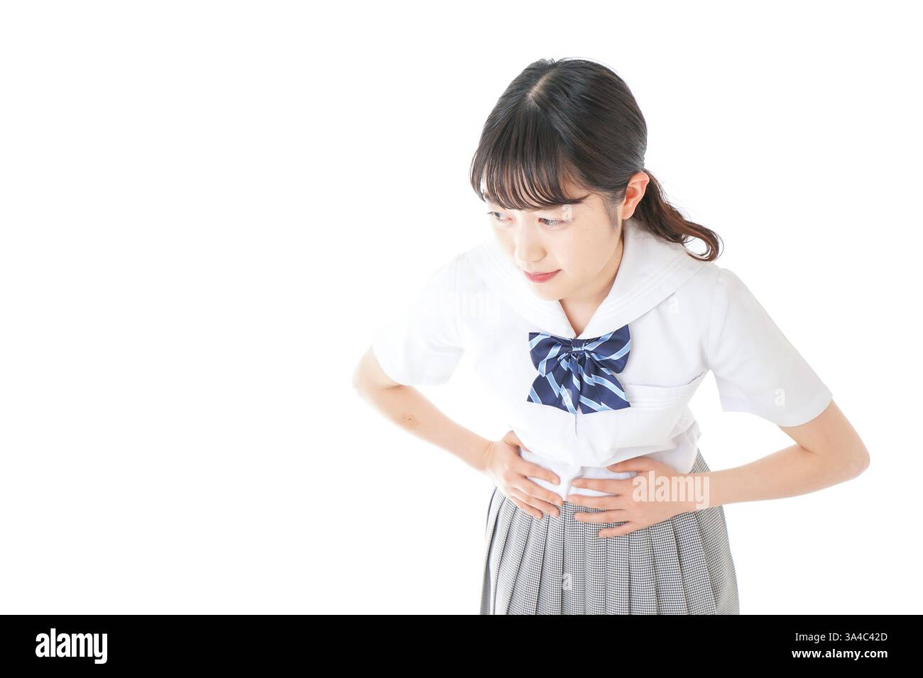 Schoolgirl in school uniform suffering from menstrual cramps Stock