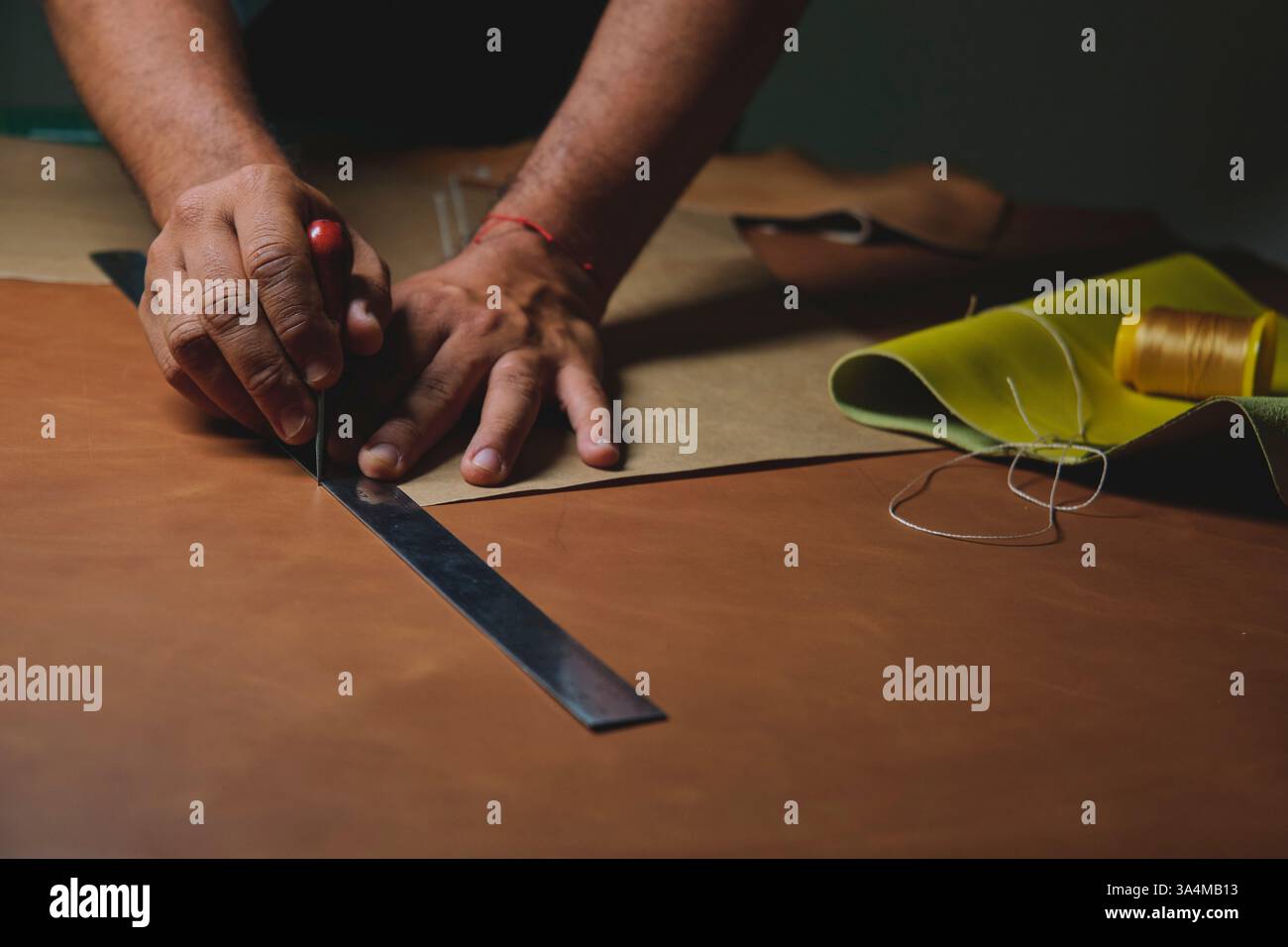 Shoemaker working leather using tools and ruler Stock Photo