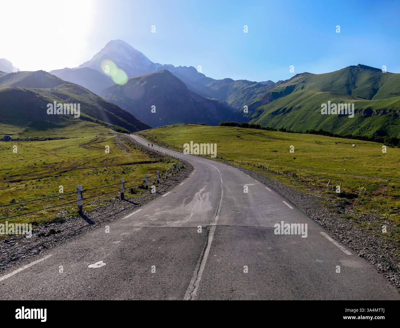 A road winds past Mount Kazbeg in the Caucasus Mountains of Georgia. Stock Photo