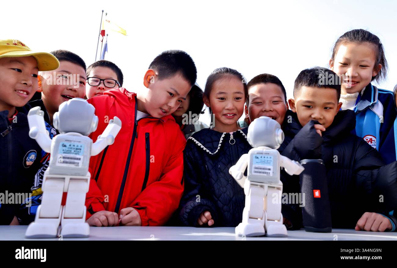 ZHANGYE, CHINA - MARCH 19, 2025 - Students talk to a robot at the ...