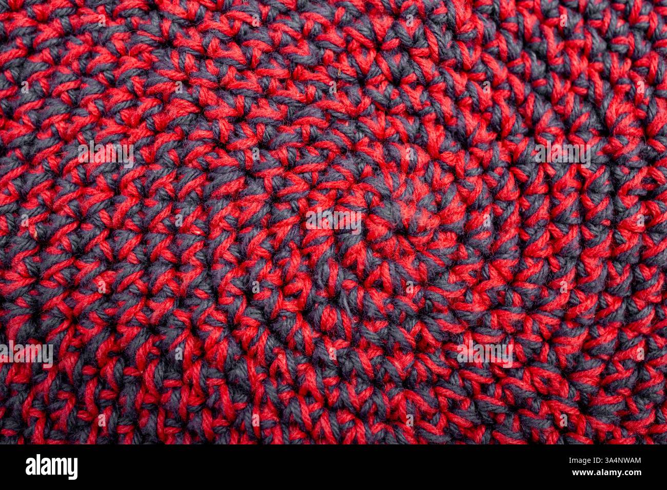 Knitted with a crochet hook, spiral shaped pattern texture, abstract  backdrop Stock Photo