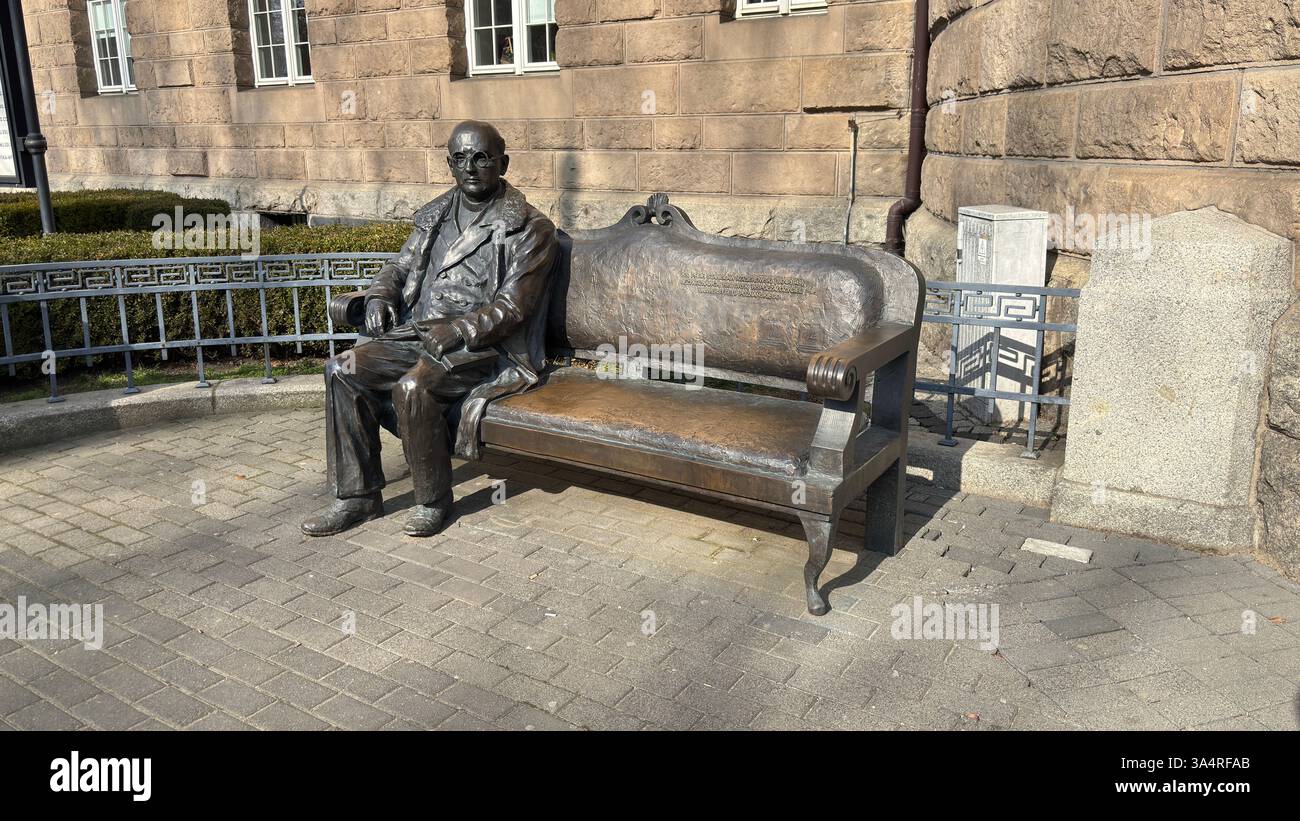 Poland - March 10th 2025: Statuę on a bench of Ławeczka Stanisława Kozierowskiego outside the University of Medical Sciences Poznan, Poland - Smartphone Captured Stock Image