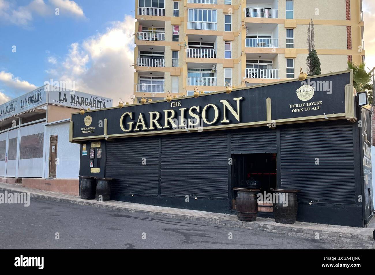 The Garrison British Pub in front of the Torres de Yomely Apartment Complex in Playa de las Américas. Arona, Tenerife, Canary Islands, Spain. - Smartphone Captured Stock Image
