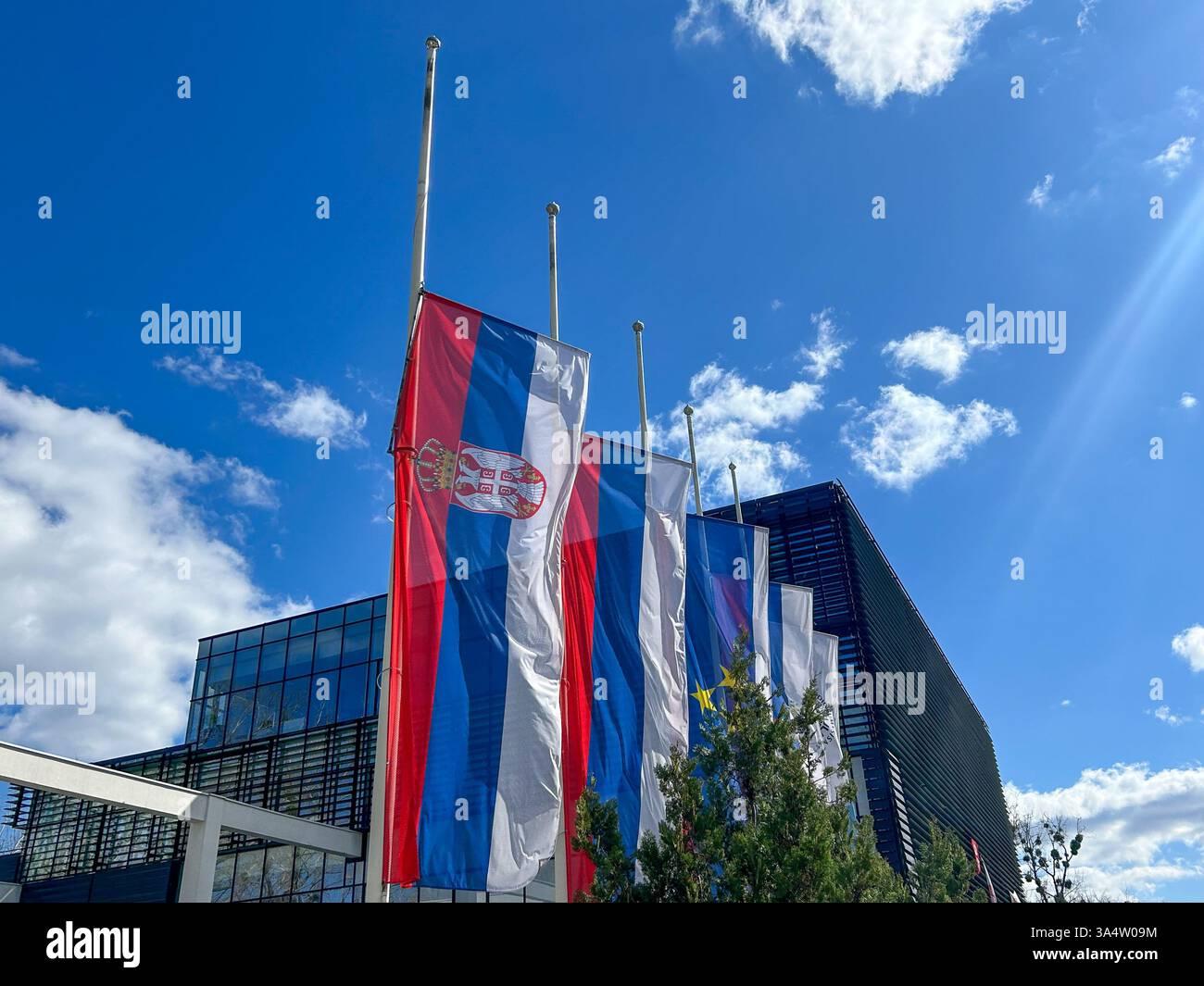 Serbian flags lowered to half-mast in honor of the Day of Mouring, symbolizing respect and remembrance. - Smartphone Captured Stock Image