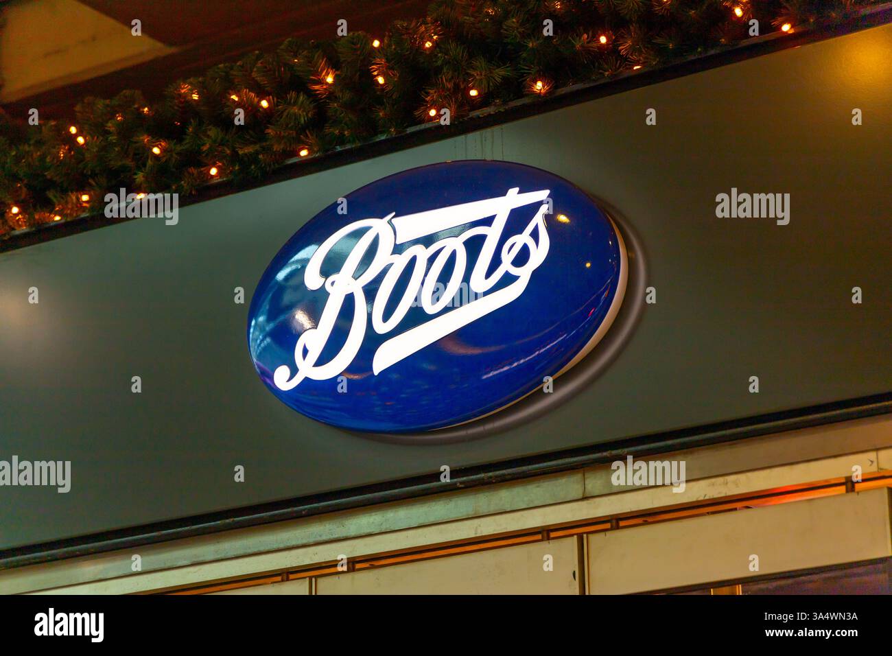 Boots logo above the shop entrance, Boots is a British health and beauty retailer and pharmacy chain in the United Kingdom. Stock Photo