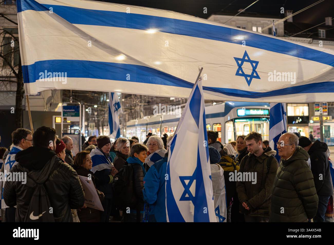 19-03-2023 Zurich, Switzerland. A small group of pro-Israeli demonstrators gathered at Paradeplatz in the evening. People carrying Israeli flags and b Stock Photo