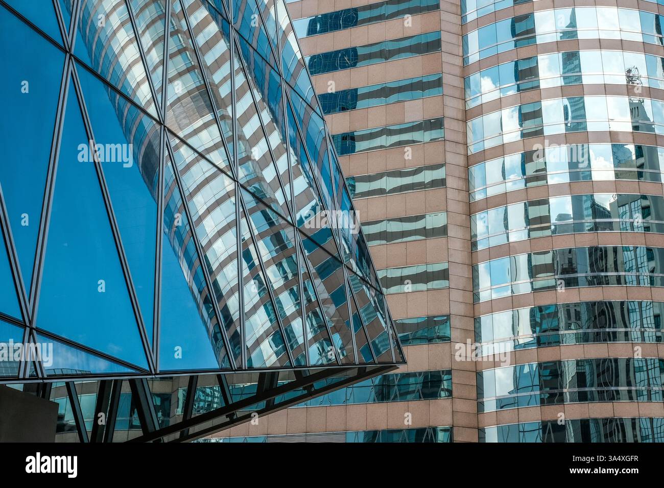 Contemporary architecture in Central Hong Kong comprised of reflective glass, steel and stone elements. Stock Photo