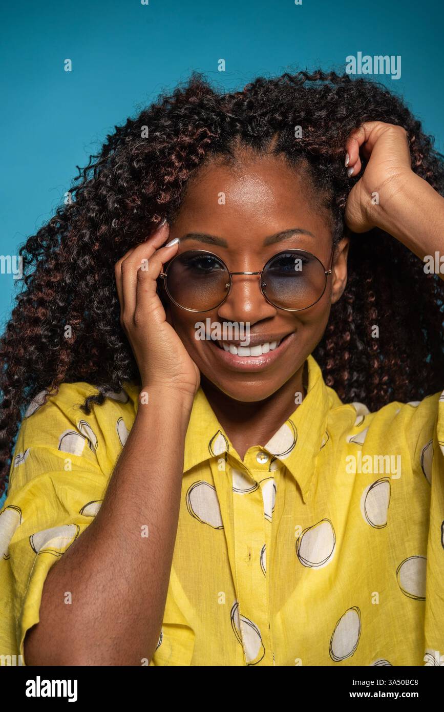 Happy African American girl with curly hair and glasses smiles at the ...
