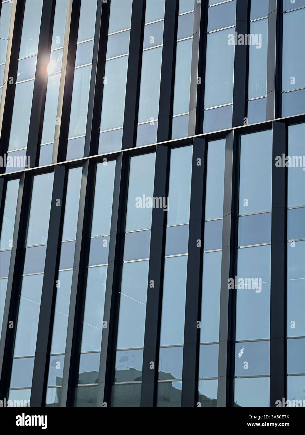 Glass skyscraper reflecting sunlight, modern architecture showcasing geometric symmetry. Glass surfaces enhance contemporary aesthetic, urban - Smartphone Captured Stock Image
